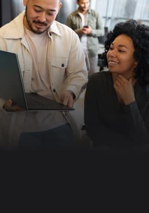 A man shows a woman something on his laptop