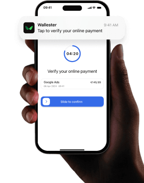 A hand is holding a smatphone with a notification from the Wallester app