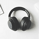 black over-ear wireless headphones placed on a white desk